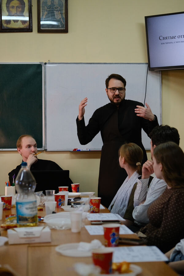 Священник ведёт беседу на встрече молодёжки